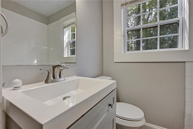 bathroom featuring vanity, toilet, and a wealth of natural light