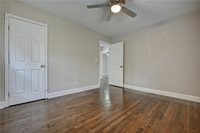 empty room featuring ceiling fan and dark hardwood / wood-style flooring