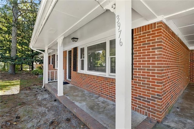 view of side of home featuring covered porch