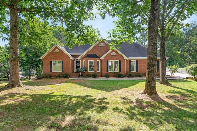 ranch-style house with a front yard and brick siding