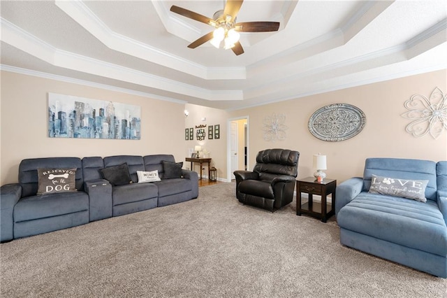 carpeted living area featuring ceiling fan, a tray ceiling, and ornamental molding