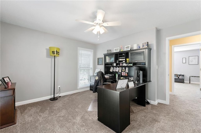 carpeted office with baseboards and ceiling fan