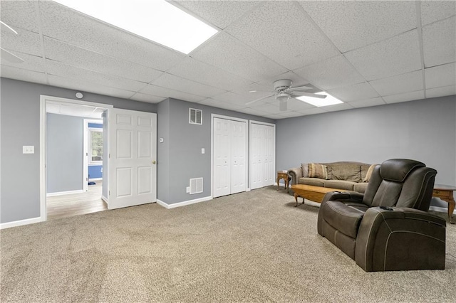 carpeted living room featuring visible vents, ceiling fan, a paneled ceiling, and baseboards