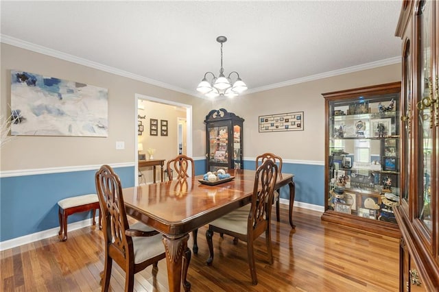 dining space featuring baseboards, a notable chandelier, light wood-style flooring, and crown molding