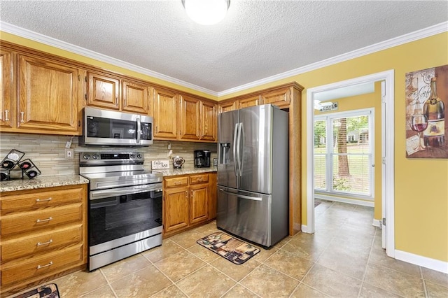 kitchen with backsplash, brown cabinets, appliances with stainless steel finishes, and light stone counters