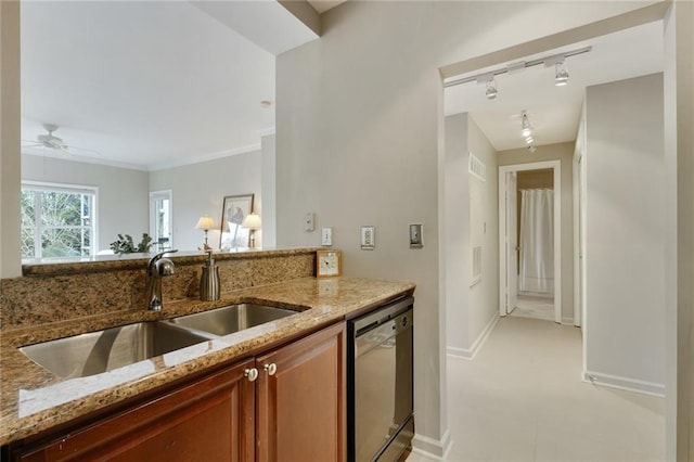 kitchen with baseboards, brown cabinetry, dishwashing machine, light stone countertops, and a sink