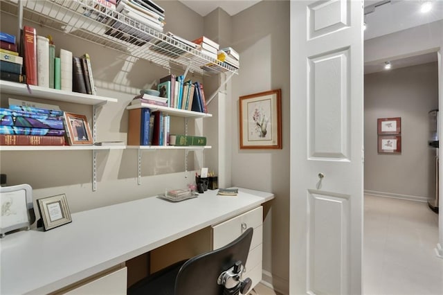 office space featuring built in desk and baseboards