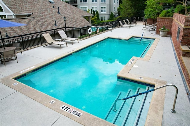 pool featuring fence and a patio