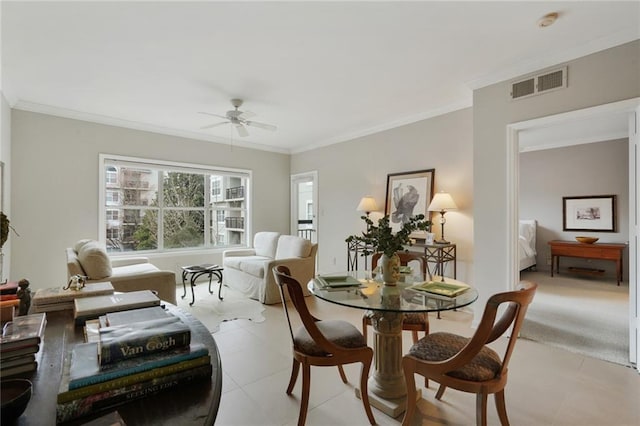 dining space featuring ceiling fan, light tile patterned floors, visible vents, and crown molding