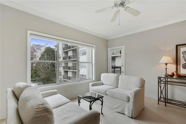 living room with baseboards, a ceiling fan, and crown molding