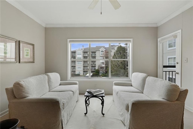 sitting room featuring ceiling fan, baseboards, and crown molding
