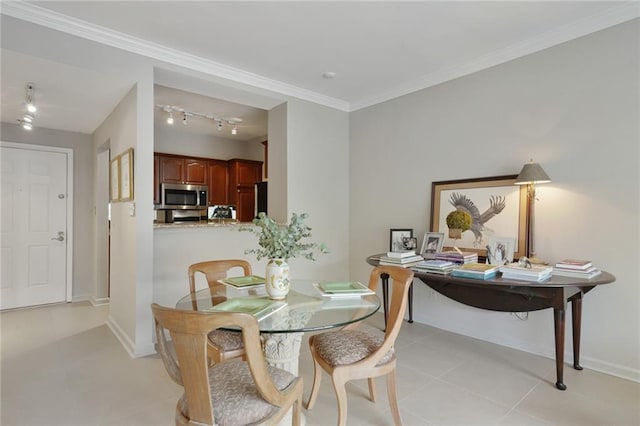 dining area with ornamental molding, track lighting, baseboards, and light tile patterned floors