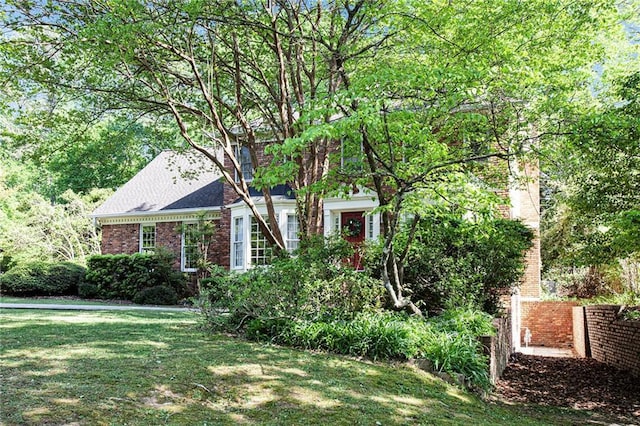 view of front of house featuring brick siding and a front lawn