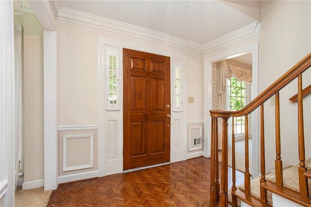 foyer entrance featuring stairs and crown molding