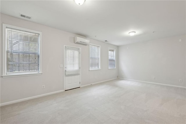 carpeted empty room featuring an AC wall unit