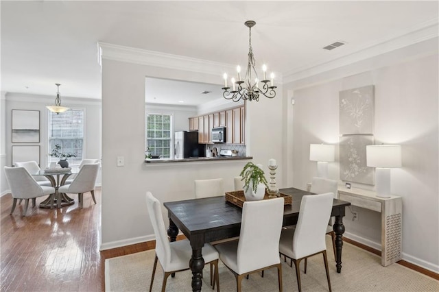 dining room featuring ornamental molding and light hardwood / wood-style floors