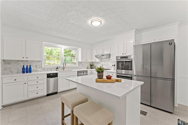 220 Hollyridge Dr, Roswell, GA 30076 - kitchen with appliances with stainless steel finishes, light tile patterned floors, white cabinets, a textured ceiling, and ornamental molding