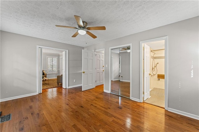 220 Hollyridge Dr, Roswell, GA 30076 - unfurnished bedroom featuring wood finished floors, a textured ceiling, a ceiling fan, and ensuite bathroom