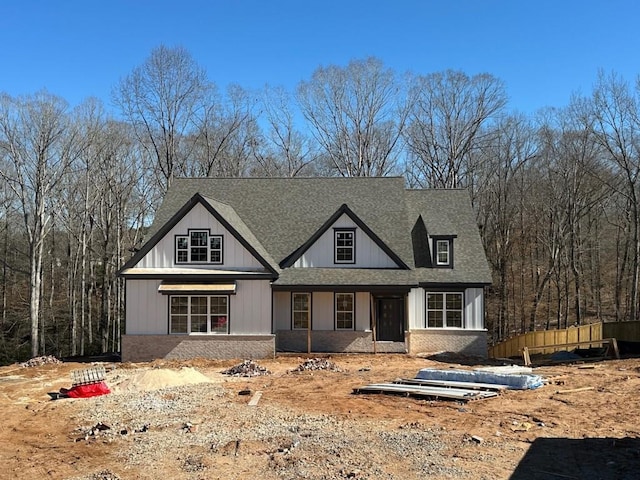 modern farmhouse with roof with shingles and brick siding