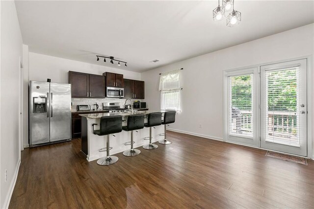 105 Arbor Creek Trl, Dallas, GA 30157 - kitchen featuring stainless steel appliances, a kitchen bar, decorative backsplash, dark brown cabinetry, and dark wood-style flooring