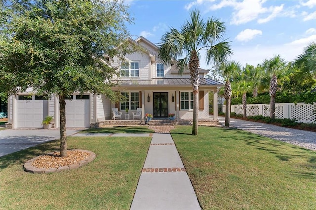 view of front of home with a garage, a front yard, and covered porch