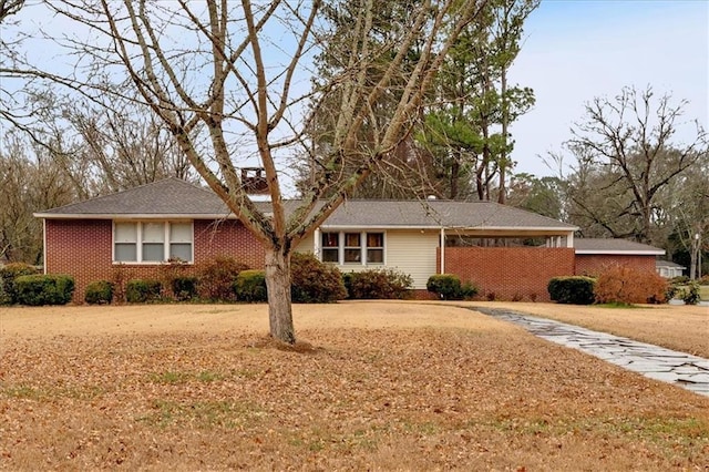 ranch-style home featuring brick siding and a front yard