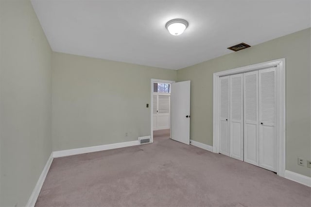 unfurnished bedroom with carpet, baseboards, and visible vents