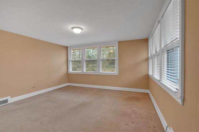 spare room featuring visible vents, baseboards, and carpet floors