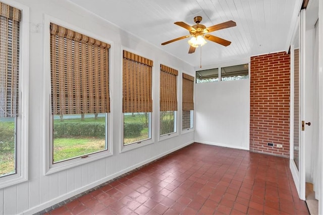 unfurnished sunroom featuring plenty of natural light and a ceiling fan