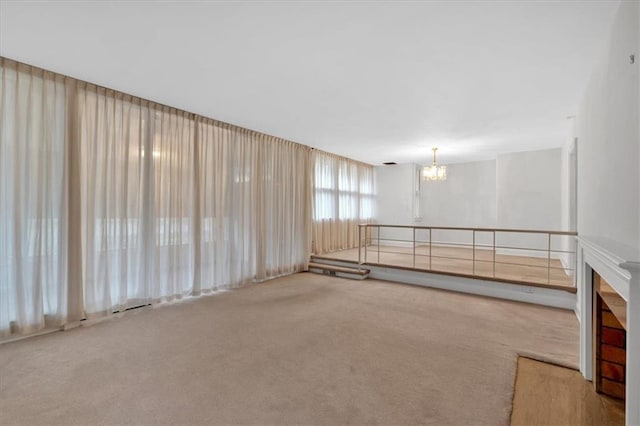 spare room with carpet floors and a chandelier