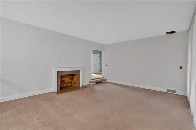 unfurnished living room with carpet flooring, a fireplace with flush hearth, baseboards, and visible vents