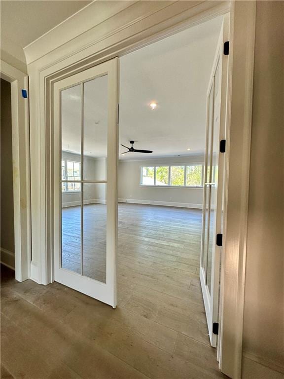 corridor with hardwood / wood-style floors and french doors