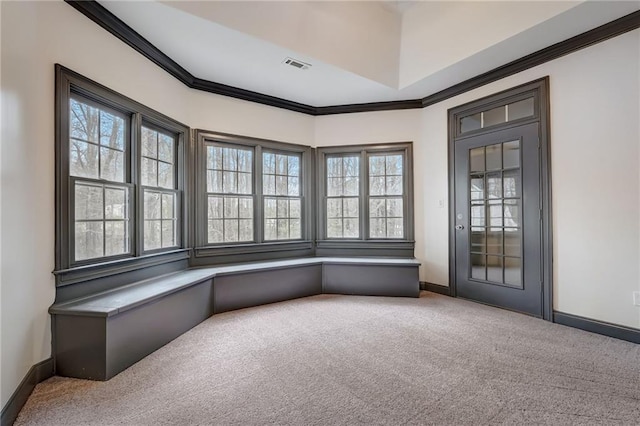 spare room with plenty of natural light, crown molding, and carpet