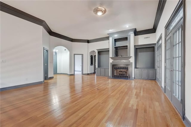 unfurnished living room with french doors, crown molding, and light hardwood / wood-style floors