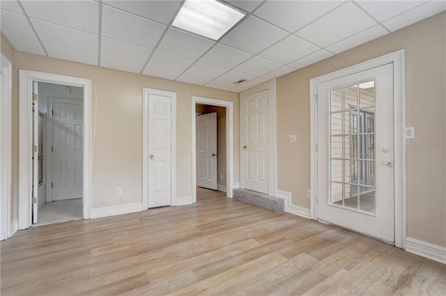 empty room featuring light hardwood / wood-style floors and a paneled ceiling