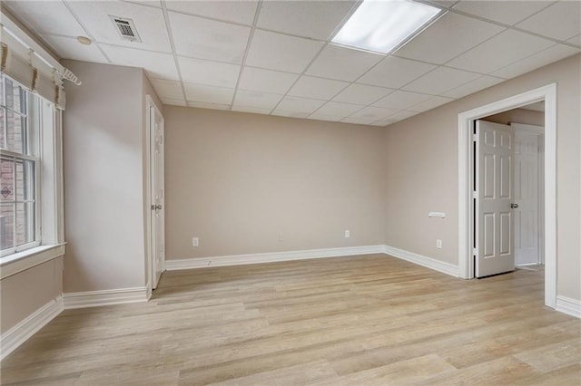 unfurnished room with a paneled ceiling and light hardwood / wood-style flooring