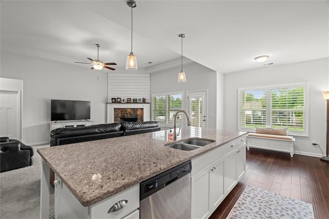 777 Tucker Trl, Bremen, GA 30110 - kitchen featuring stainless steel dishwasher, a sink, a fireplace, light stone counters, and white cabinetry
