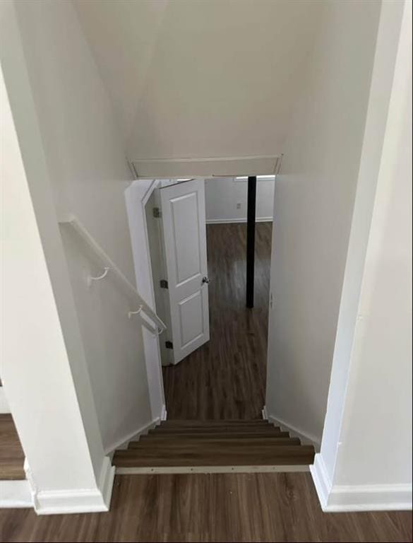stairs featuring wood finished floors and baseboards