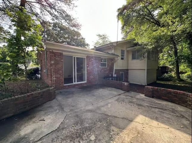 back of property with a patio area and brick siding