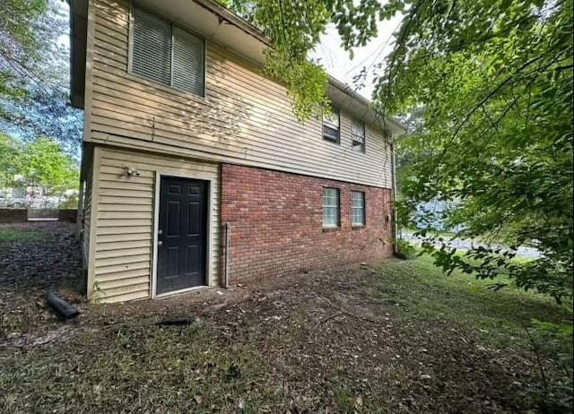 back of property featuring brick siding