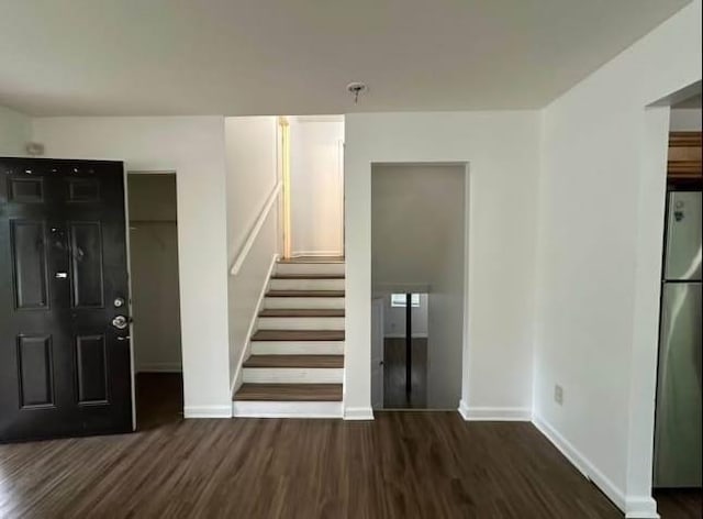 interior space featuring baseboards, stairs, and wood finished floors