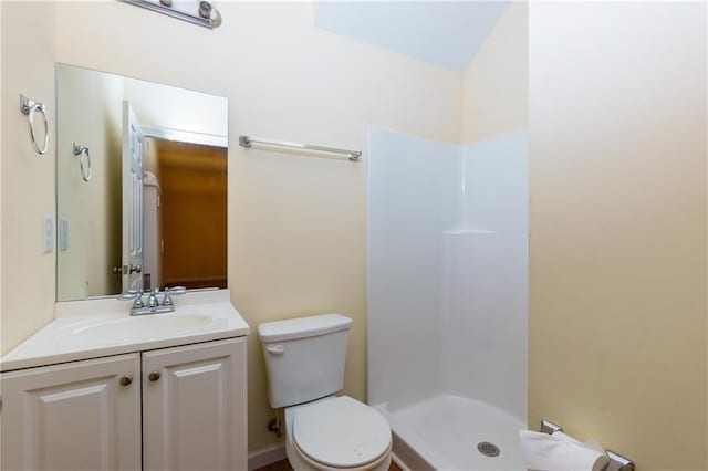 bathroom featuring toilet, vanity, and a shower