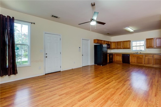 unfurnished living room featuring ceiling fan, light hardwood / wood-style flooring, sink, and a healthy amount of sunlight