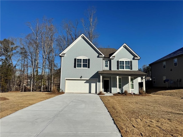 view of front of home with a garage, a front yard, and covered porch