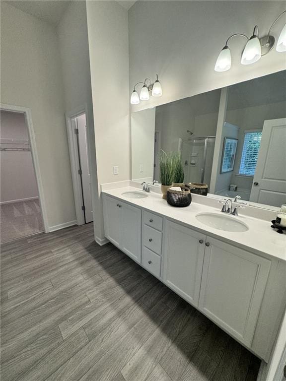 4005 Riverchess Dr SW, Atlanta, GA 30331 - bathroom featuring a towering ceiling, vanity, a shower with shower door, and hardwood / wood-style floors