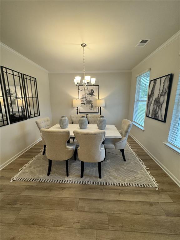 4005 Riverchess Dr SW, Atlanta, GA 30331 - dining space with ornamental molding, wood-type flooring, and a chandelier