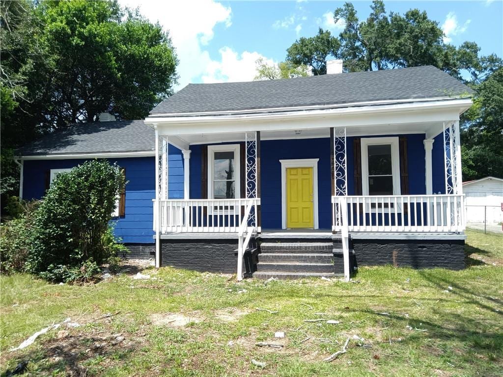 bungalow-style home with a porch and a front lawn