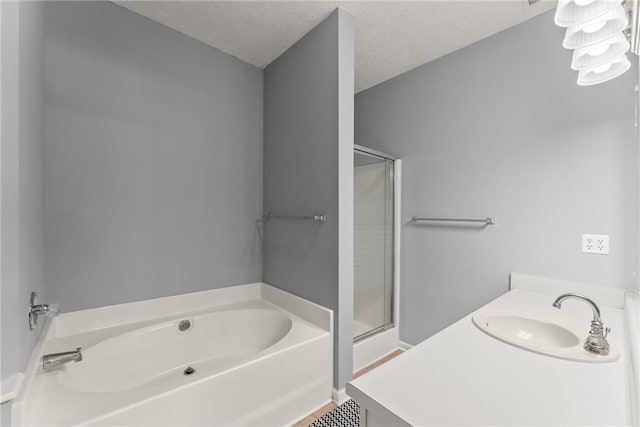 full bathroom with a bath, a shower stall, a textured ceiling, and a sink