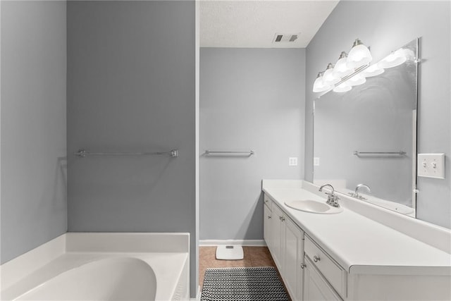 bathroom featuring vanity, visible vents, a textured ceiling, a garden tub, and tile patterned floors