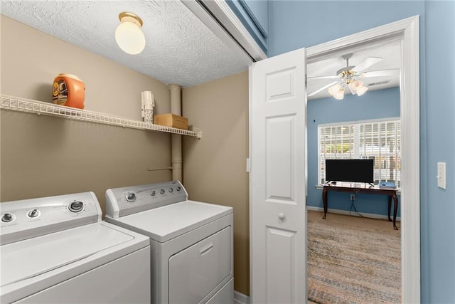 laundry area featuring washing machine and clothes dryer, laundry area, a textured ceiling, and baseboards